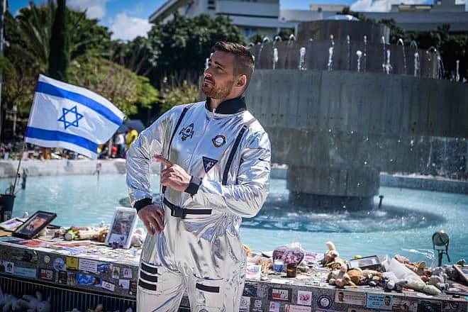 At Dizengoff Square in  Tel Aviv, a man dons a costume ahead of the Jewish holiday of Purim in the backdrop of photos of the hostages being held captive by Hamas in the Gaza Strip, March 22, 2024. Photo by Avshalom Sassoni/Flash90.