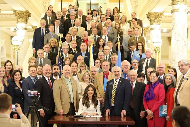 South Dakota Gov. Kristi Noem (seated) signs a bill codifying the IHRA working definition of antisemitism into state law at the state capitol in Pierre on March 6, 2024. Credit: Courtesy of South Dakota Office of the Governor.