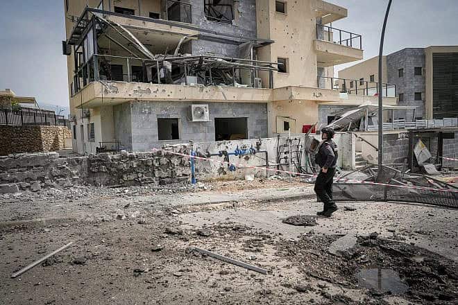 An Israeli solder views the damage after a rocket fired by Hezbollah in Lebanon hit the Galilee city of Kiryat Shmona, March 27, 2024. Photo by Ayal Margolin/Flash90.