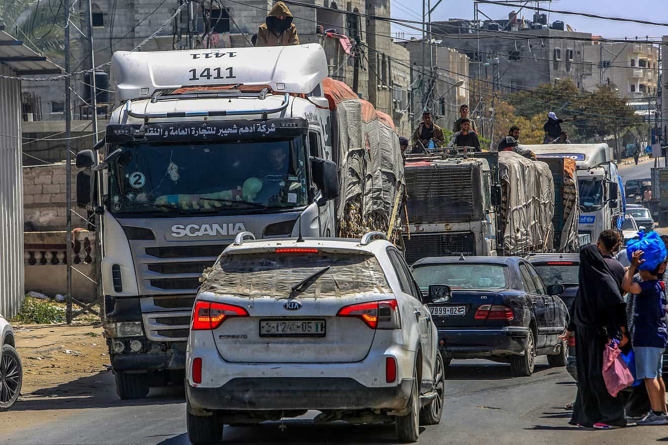 Armed and masked Palestinians seen on trucks loaded with international humanitarian aid entering Gaza through the Israeli Kerem Shalom Crossing, in the southern Gaza Strip, April 3, 2024. Photo by Abed Rahim Khatib/Flash90.
