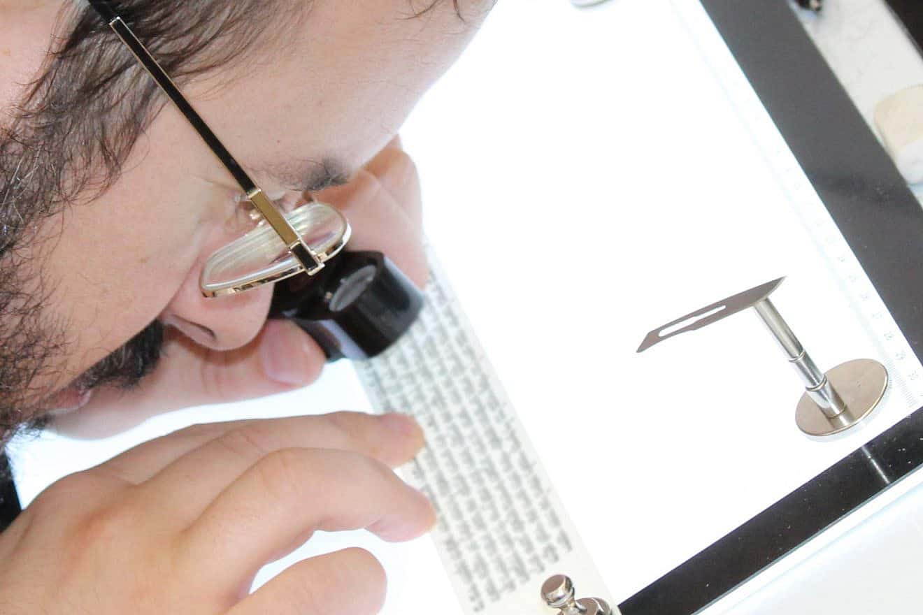 A STAMP-certified expert checks the text of a tefillin. Credit: Courtesy of the Orthodox Union.