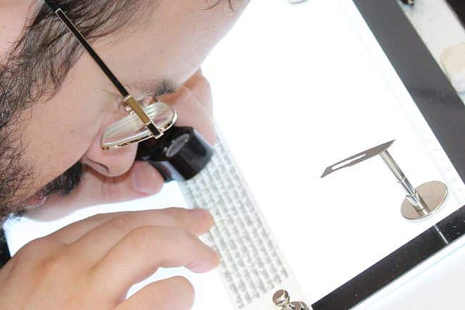 A STAMP-certified expert checks the text of a tefillin. Credit: Courtesy of the Orthodox Union.