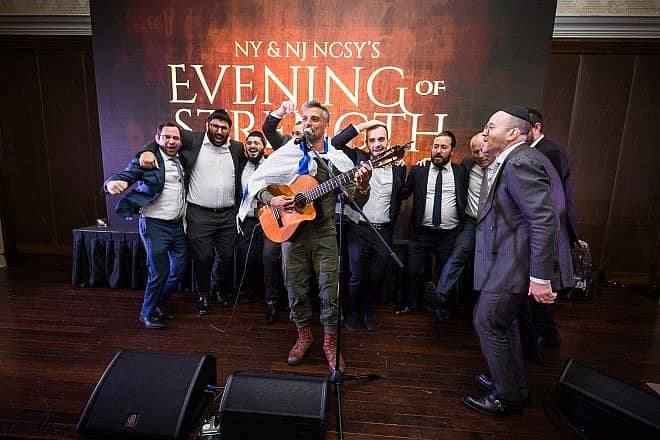 Israel Defense Forces paratrooper Sgt. Maj. Noam Buskila, a singer serving on Israel’s northern border, entertains a lively crowd at NY & NJ NCSY’s “Evening of Strength.” Credit: Courtesy of the Orthodox Union.