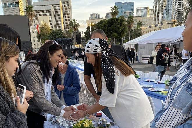 Lea Schenirer, a Pilates instructor and social-media influencer, encourages women to light candles before Shabbat at “Hostages Square” in Tel Aviv. Photo by Alanna Cooper.