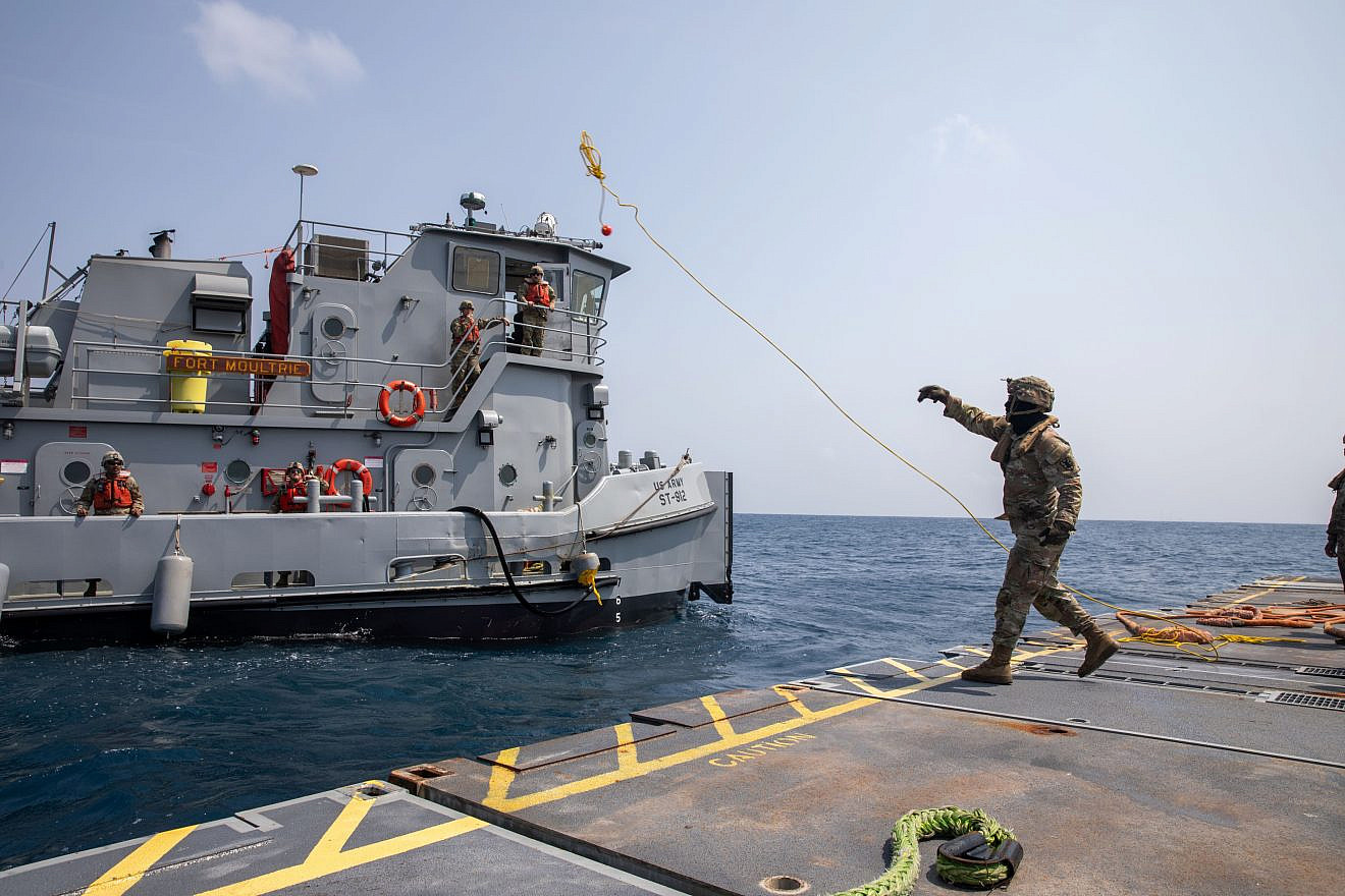 A U.S. Army Soldier assigned to the 7th Transportation Brigade (Expeditionary) tosses a line to a U.S. Army tug vessel from the roll-on, roll-off distribution facility—or floating pier—off the shore of Gaza on May 1, 2024. Credit: U.S. Central Command.