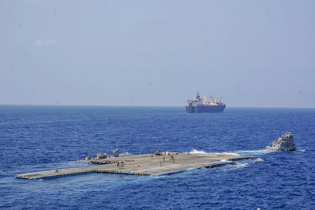 The roll-on, roll-off distribution facility, or floating pier, is pulled by a U.S. Army tug boat from the 7th Transportation Brigade (Expeditionary) off the shore of Gaza during Operation Neptune Solace on May 1, 2024. Credit: U.S. Central Command.