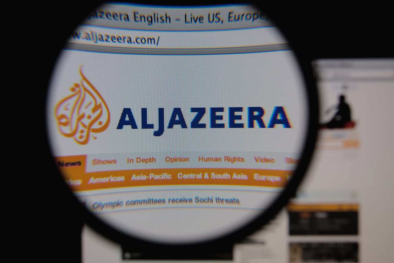 “Al Jazeera” homepage through a magnifying glass, Jan. 25, 2014. Credit: Gil C/Shutterstock.