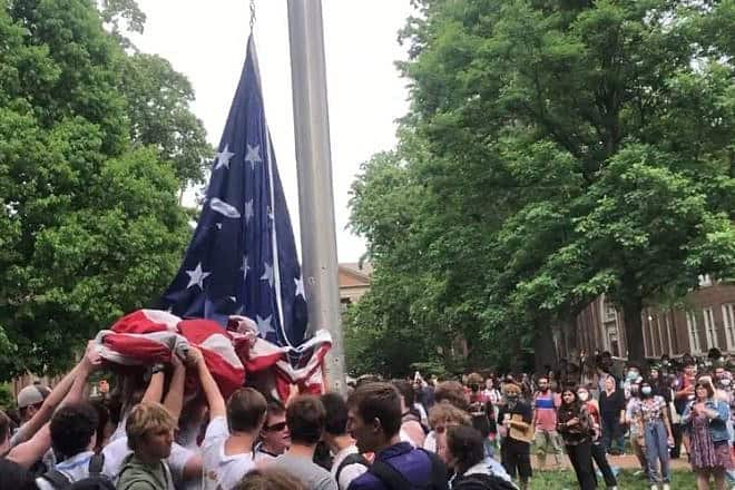 Jewish and non-Jewish students at the University of North Carolina at Chapel Hill hold up the American flag after anti-Israel protesters attempted to change it to the Palestinian flag, May 2024. Source: Screenshot/Bryan Anderson on X.