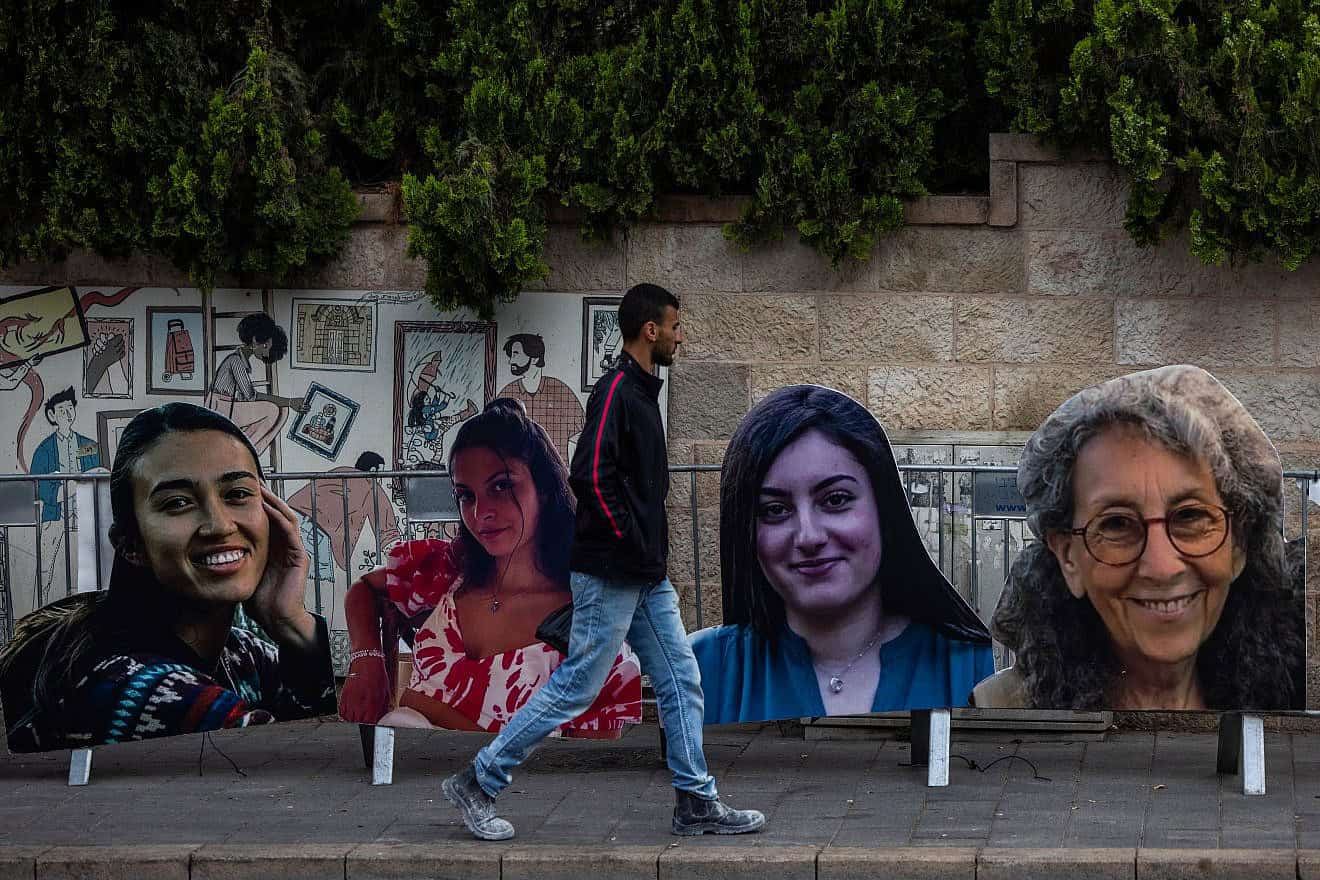 People walking next to large pictures of Israeli women held hostage in the Gaza Strip as part of a protest calling for their release, near the Prime Minister's official residence in Jerusalem, May 2, 2024. Photo by Yonatan Sindel/Flash90.