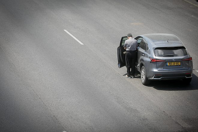 A man stands still as a two-minute siren sounded across Israel, marking Memorial Day, which commemorates the fallen Israeli soldiers and victims of terror, on the Ayalon Highway in Tel Aviv on May 13, 2024. Photo by Miriam Alster/Flash90.