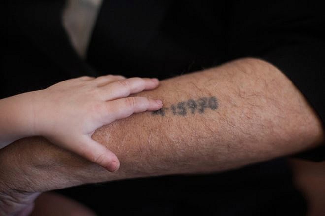A Holocaust survivor shows his grandson the prisoner number tattooed on his arm, Jerusalem, May 24, 2013. Photo by Yonatan Sindel/Flash90.