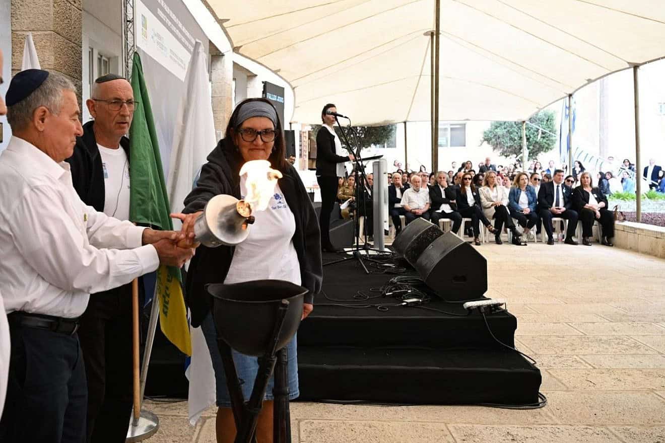Chairman of the Jewish Agency Maj. Gen. (Res.) Doron Almog lights the Yom Hazikaron memorial torch with Nicky and Chantal Young, the parents of British lone soldier Nathaniel Young, on May 13, 2024. Credit: Yuval Yosef, Zoog Productions/The Jewish Agency.