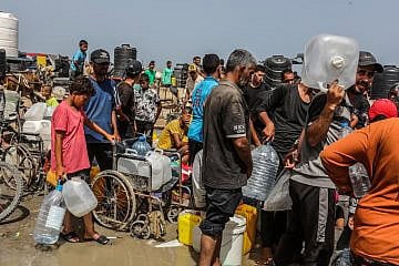 Palestinians line up in the Gaza Strip to receive drinkable water numbers while battles take place between Israel and Hamas in the southern city of Rafah on May 20, 2024. Photo by Abed Rahim Khatib/Flash90.