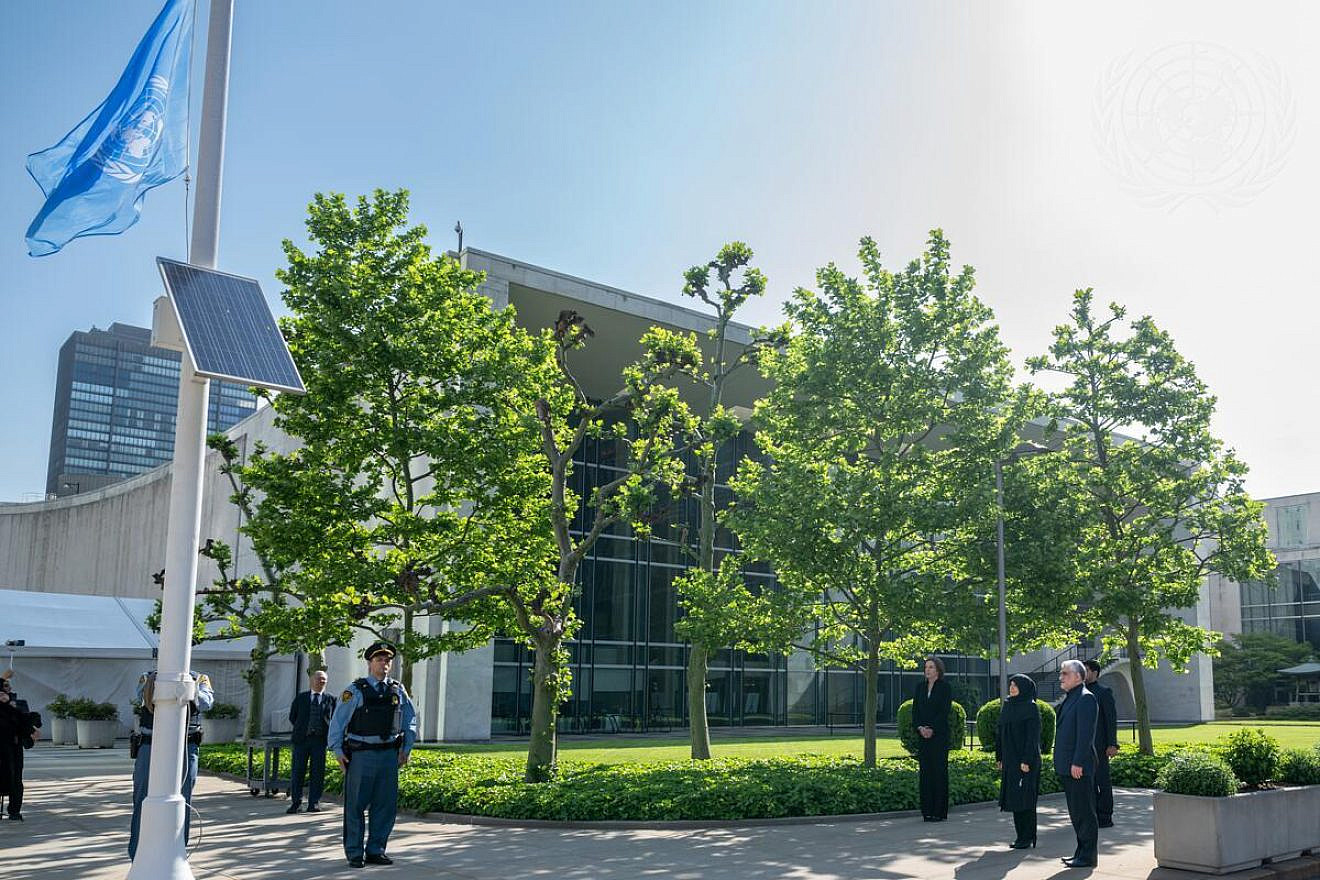 The U.N. flag is lowered to half-mast at the headquarters of the United Nations in New York City to honor Seyyed Ebrahim Raisi, the Iranian president, who died in a helicopter crash on May 19, 2024. At right is Amir Saeid Iravani, Iranian ambassador to the United Nations, on May 21, 2024. Credit: Mark Garten/U.N. Photo.