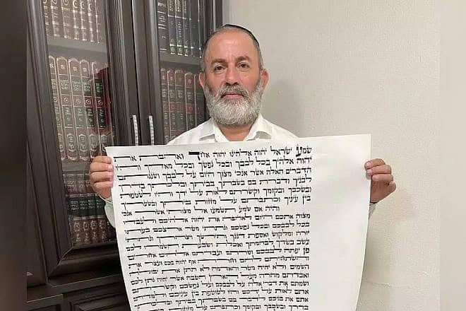 Rabbi Meir Peretz with the mezuzah scroll. Credit: Courtesy.