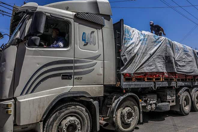 Terrorists on trucks loaded with aid entering Gaza through Israel's Kerem Shalom Crossing, April 3, 2024. Photo by Abed Rahim Khatib/Flash90.