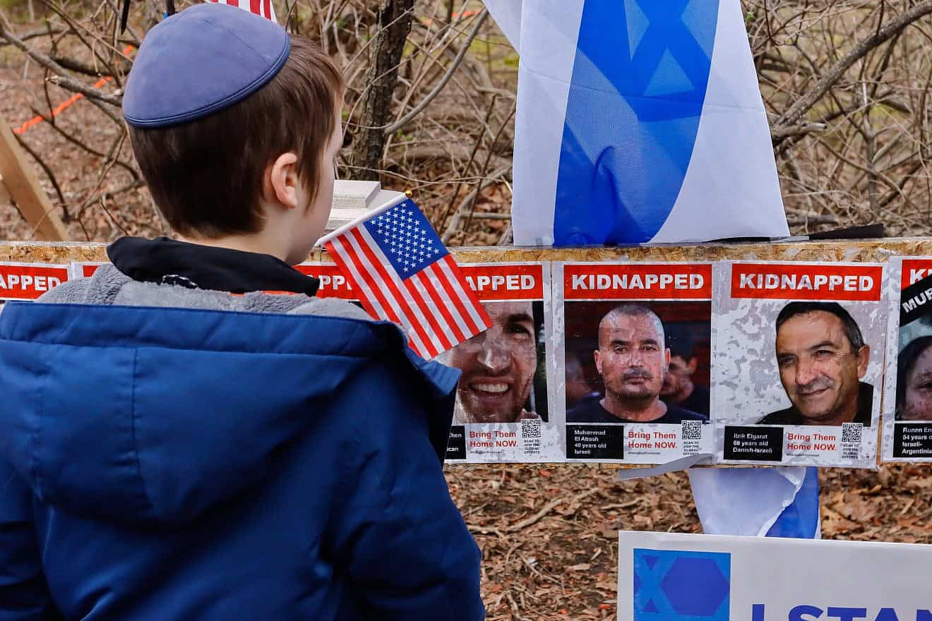 A boy views a memorial in Newton, Mass., honoring those who were kidnapped and taken into the Gaza Strip by Hamas on Oct. 7, after it was vandalized on April 7, 2024. Photo by Arthur Mansavage/Shutterstock.