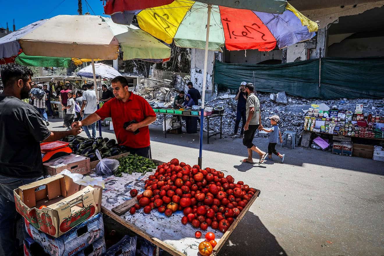Palestinians shopping at a market next to destroyed buildings in Deir al-Balah, in the central Gaza Strip, May 31, 2024. Photo by Abed Rahim Khatib/Flash90.