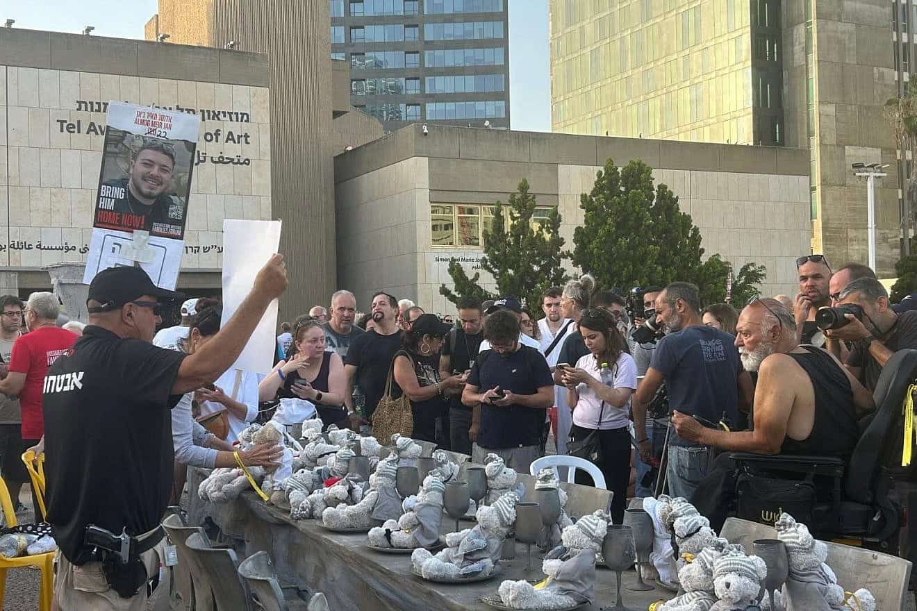 People sing "Am Yisrael Chai" before an empty Shabbat table at "Hostage Square" in Tel Aviv, June 8, 2024. Photo by Amelie Botbol.