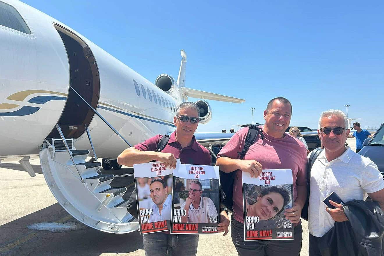 From left: Oct. 7 survivors Sharon Shevo and Avida Bachar and Israel Premier Tech co-owner Sylvan Adams prepare to board a flight to Italy for the Tour de France, at Ben Gurion Airport, June 26, 2024. Photo by Amelie Botbol.