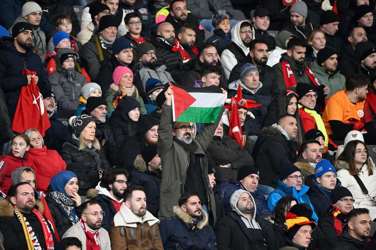 A man displays a PLO flag during the international friendly soccer match between Germany and Turkey at the Olympic Stadium in Berlin in preparation for the UEFA Euro 2024 tournament, Nov. 18, 2023. Photo by Tobias Schwarz/AFP via Getty Images.