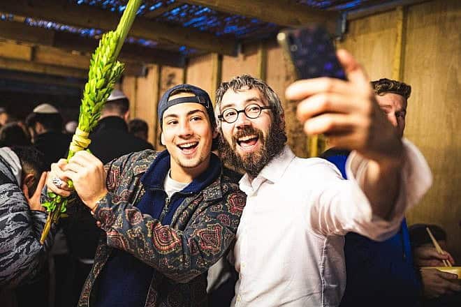 Rabbi Mendy Lent of Chabad on Campus at the University of Nottingham celebrates the Jewish holiday of Sukkot with students. Credit: Chabad on Campus/Chabad.org.