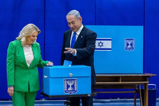 Prime Minister Benjamin Netanyahu votes in the Israeli general election as his wife, Sara look on, Nov. 1, 2022. Photo by Olivier FitoussiFlash90.