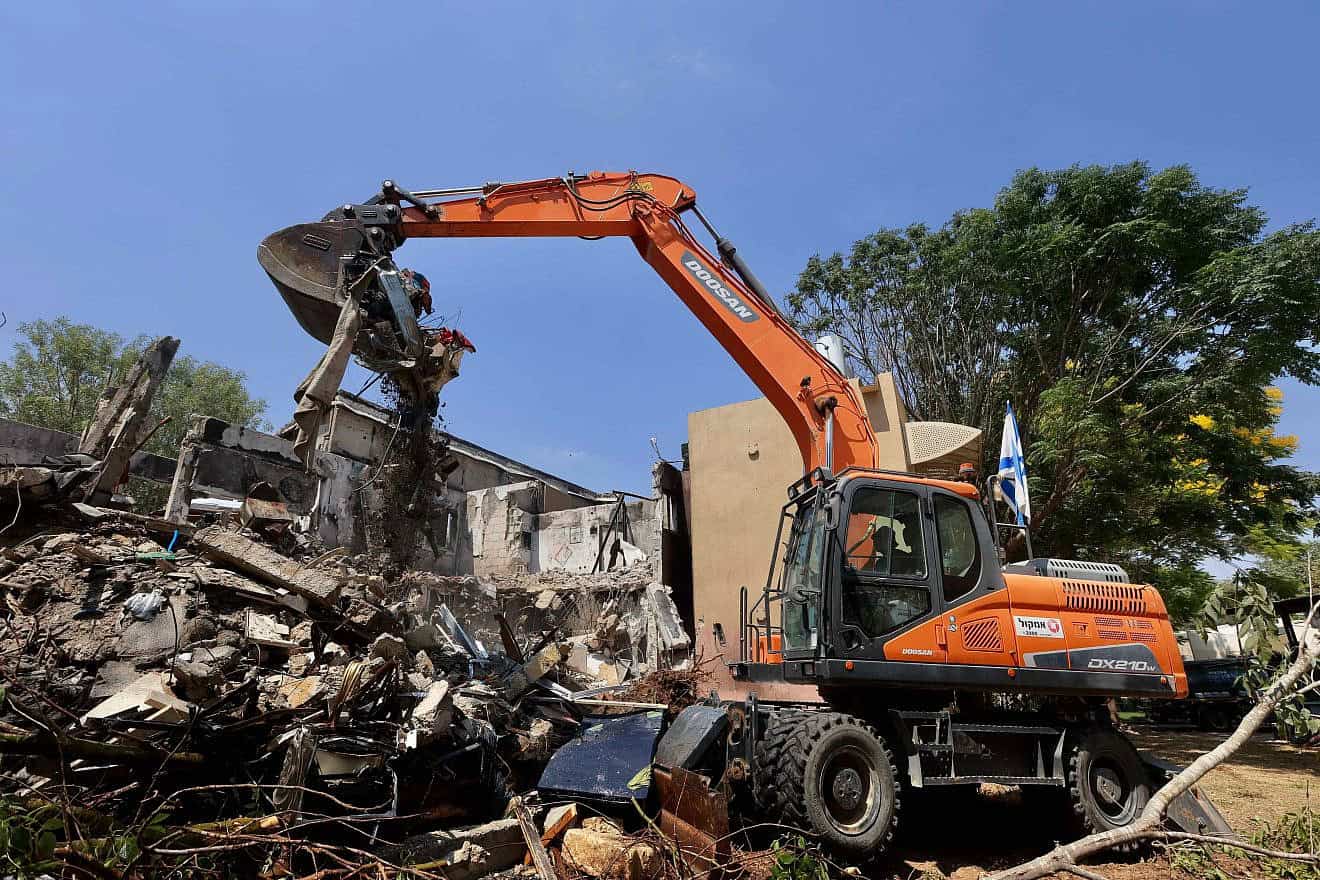 A bulldozer destroys a house that was damaged during the Oct. 7 massacre in Kibbutz Be'eri near the Israeli border with the Gaza Strip, as part of a project rebuilding the destroyed homes and infrastructure in the kibbutz, July 7, 2024. Photo by Oren Cohen/Flash90.