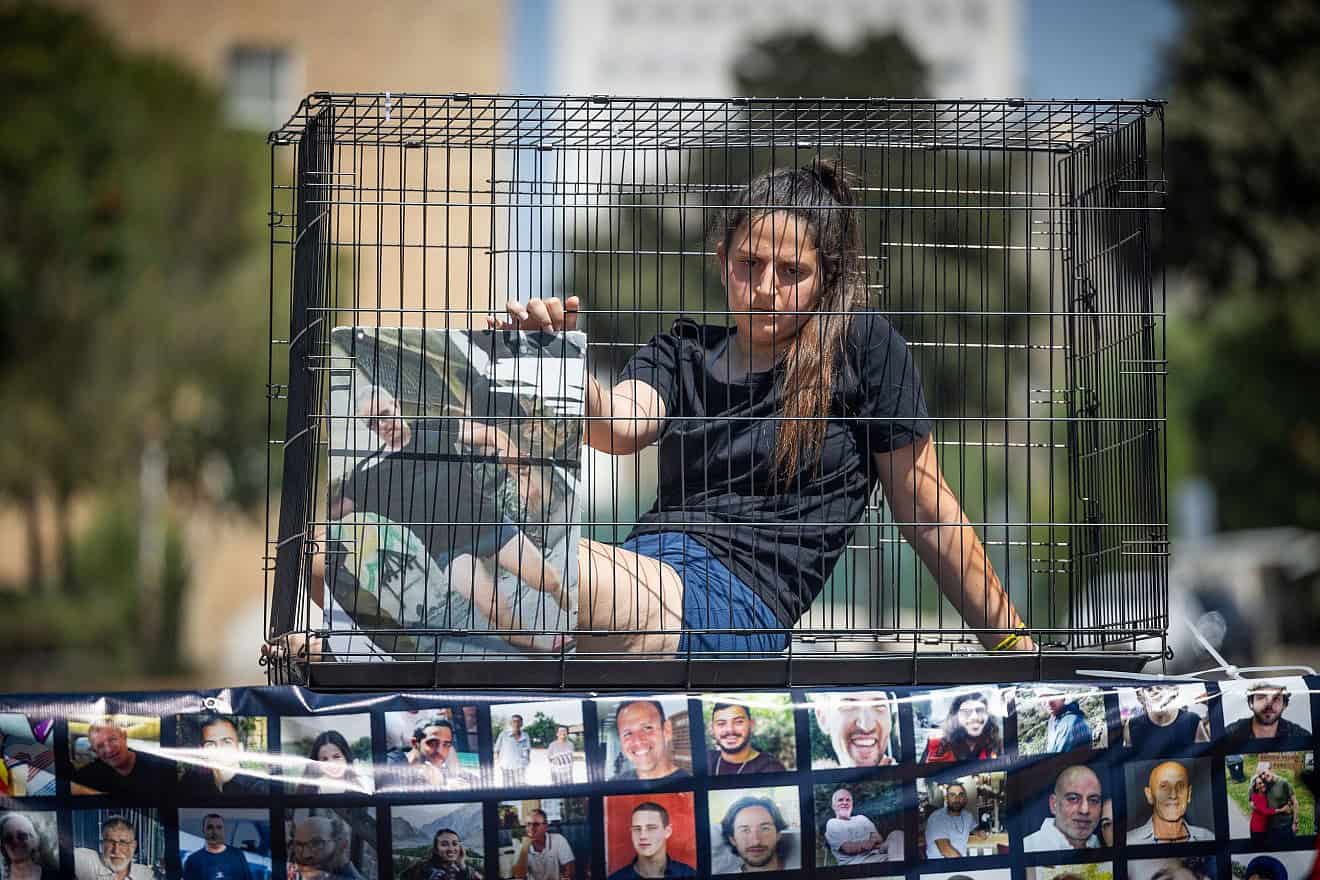 Relatives of Israelis held hostage by Hamas terrorists in Gaza sitting in cages protest for their release outside the Knesset in Jerusalem, July 10, 2024. Photo by Yonatan Sindel/Flash90.