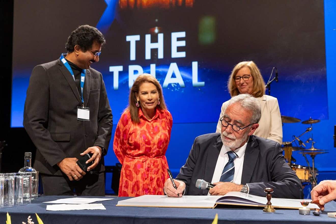 Jack van der Tang signs the decree in The Hague as his wife, Inge (right), Rev. Satish Kumar of India and former Rep. Michelle Bachmann look on, July 4, 2024. Photo by Chris van Beek.