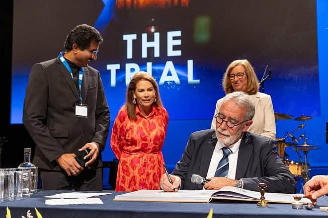 Jack van der Tang signs the decree in The Hague as his wife, Inge (right), Rev. Satish Kumar of India and former Rep. Michelle Bachmann look on, July 4, 2024. Photo by Chris van Beek.