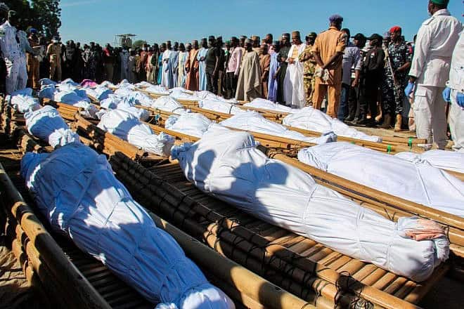 Mourners in Zabarmari, Nigeria attend the funeral of 43 farm workers, who were killed by Islamist Boko Haram terrorists, on Nov. 29, 2020. Credit: Audu Marte / AFP via Getty Images.