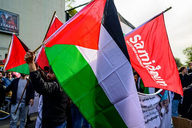 Members of the Samidoun Palestinian Prisoner Solidarity Network wave Palestinian flags during the "Revolutionary May Day" demonstration in Berlin, May 1, 2023. Photo by John MacDougall/AFP via Getty Images.