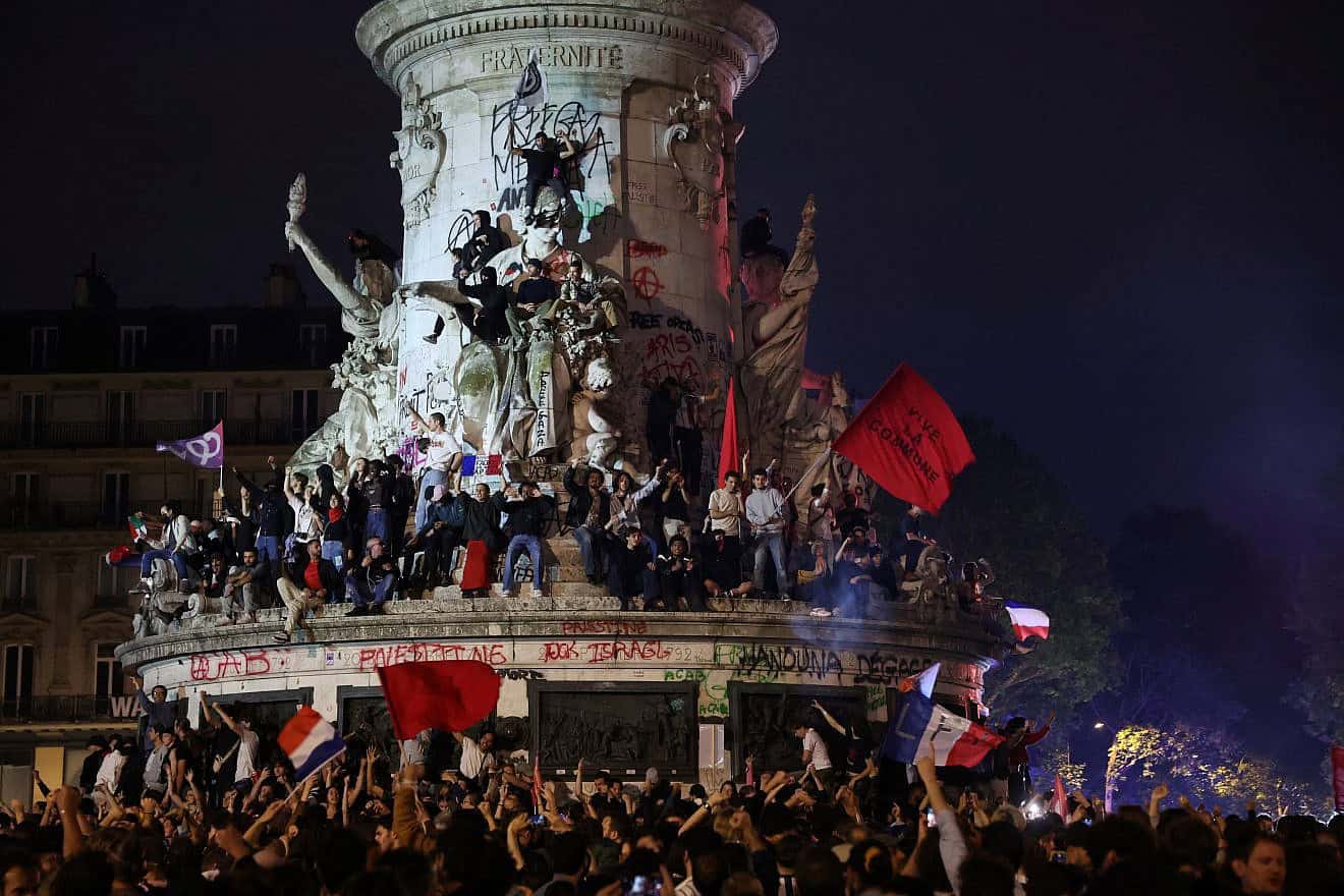 Participants gather during an election night rally following the first results of the second round of France's legislative election at Place de la Republique in Paris on July 7, 2024. A loose alliance of French left-wing parties thrown together for snap elections was on course to become the biggest parliamentary bloc and beat the far right, according to shock projected results. Photo by Emmanuel Dunand/AFP via Getty Images.