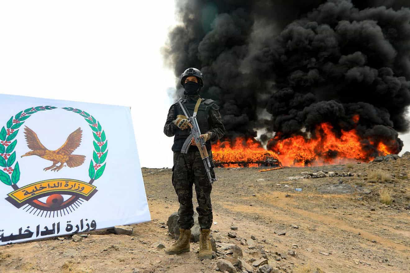 A Houthi terrorist stands guard in front of a bonfire incinerating seized narcotic substances in Sanaa, Yemen, on July 20, 2024. Credit: Mohammed Huwais/AFP via Getty Images.