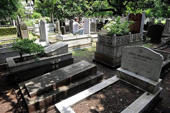 Muslim tombstone engraver Mohammad Abdul Yaseen, 74, puts a fresh coat of paint on faded tombstone letterings at the Bene Israel Jewish cemetery in Mumbai, Aug. 21, 2014. Indranil Mukherjee/AFP via Getty Images.