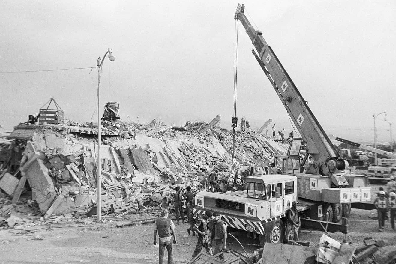 Workers use a large crane to move the rubble of a U.S. marine barracks in Beirut, Lebanon which collapsed after a truck filled with explosives crashed through a gate and smashed into the building. Over 200 marines inside the building were killed by the blast. Photo: Bettmann/Getty Images.