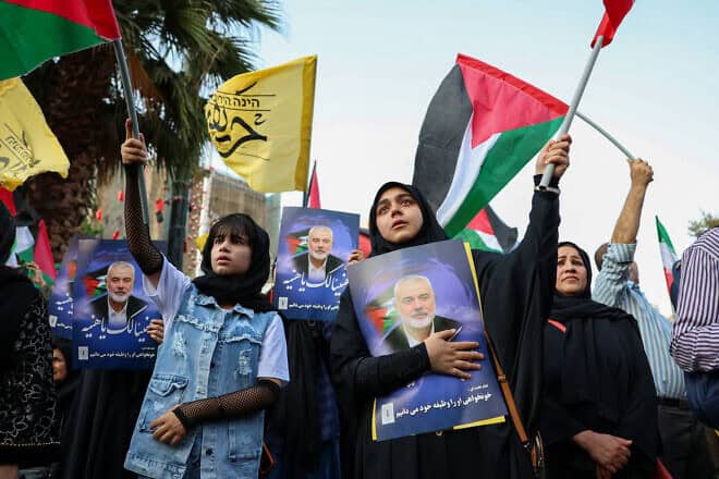 Iranians wave Palestinian flags and hold portraits of slain Hamas leader Ismail Haniyeh during a protest denouncing his killing, at Palestine square in the capital Tehran on July 31, 2024. Photo by/AFP via Getty Images.