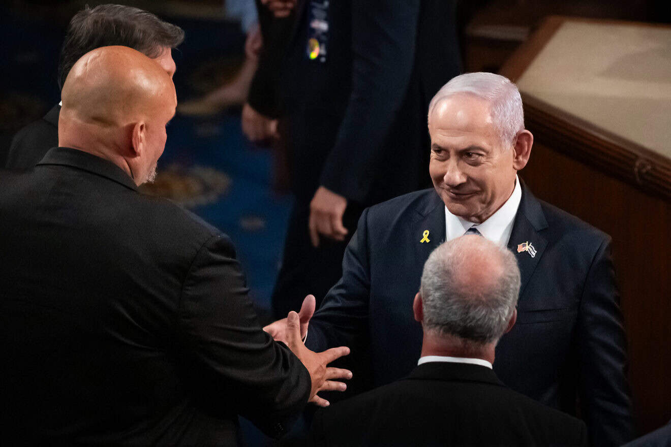 Israeli Prime Minister Benjamin Netanyahu shakes hands with Sen. John Fetterman (D-Pa.) after delivering a controversial address to a joint session of Congress in Washington, D.C., on July 24, 2024. Photo by Allison Bailey/Middle East Images/AFP via Getty Images.