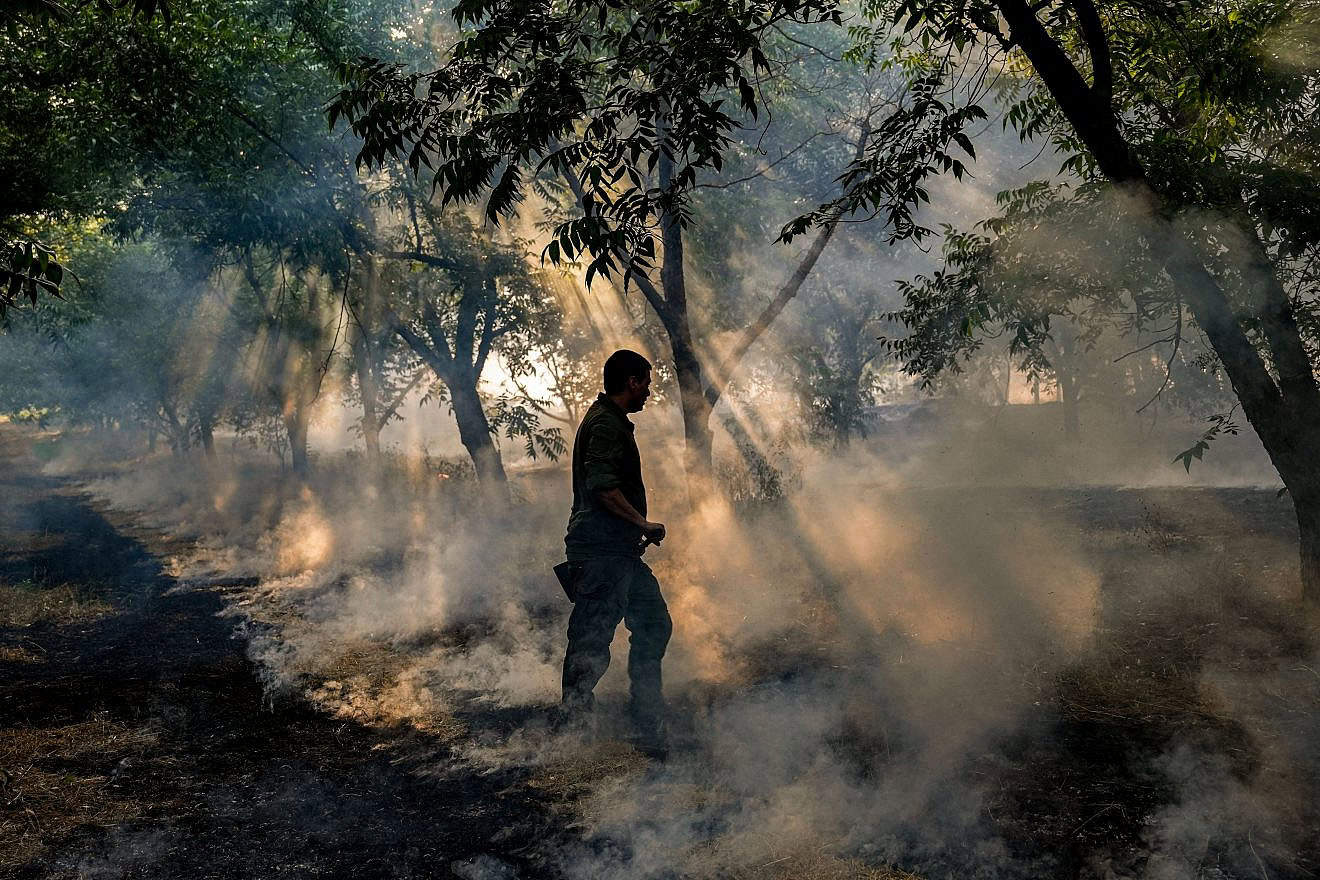 An emergency squad member tries to extinguish a forest fire Kiryat Shmona caused by rockets launched by Hezbollah in Lebanon, June 4, 2024. Photo by Ayal Margolin/Flash90.
