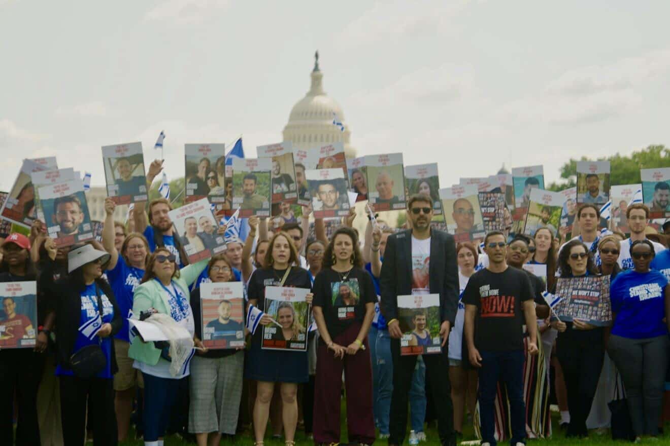 From left: Rivka Kidron, Yarden Gonen, Michael Levy and the Passages students in front of the U.S. Capitol holding aloft pictures of hostages held in Gaza. Photo by Cade Chudy.