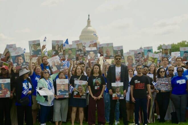 From left: Rivka Kidron, Yarden Gonen, Michael Levy and the Passages students in front of the U.S. Capitol holding aloft pictures of hostages held in Gaza. Photo by Cade Chudy.