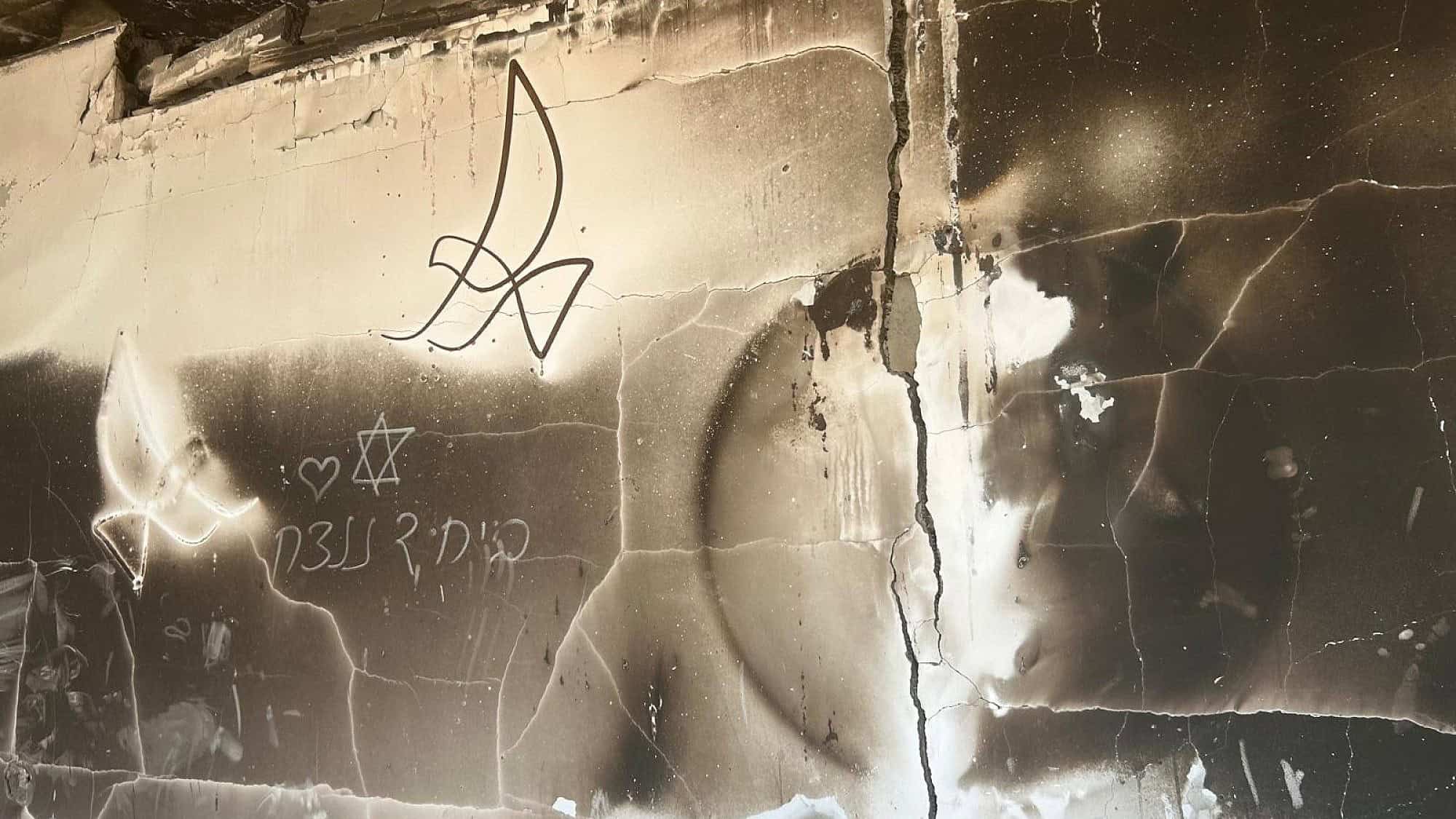 The remains of a house in Kibbutz Be'eri in southern Israel, July 22, 2024. The drawing on the wall reads: “Together, we will win.” Photo by Amelie Botbol.