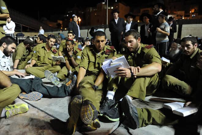 IDF soldiers sit on the ground during Tisha B'Av prayers at the Western Wall in the Old City of Jerusalem, July 16, 2013. Photo by Mendy Hechtman/Flash90.