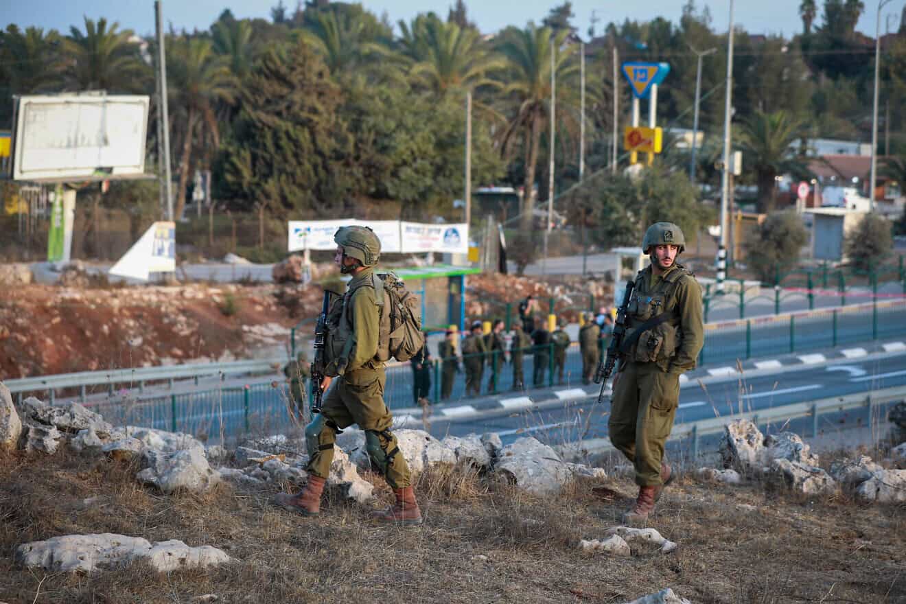 Soldiers guard a bus stop at the entrance to the Israeli town of Ofra in southern Samaria, Oct. 4, 2022. Credit: Flash90.
