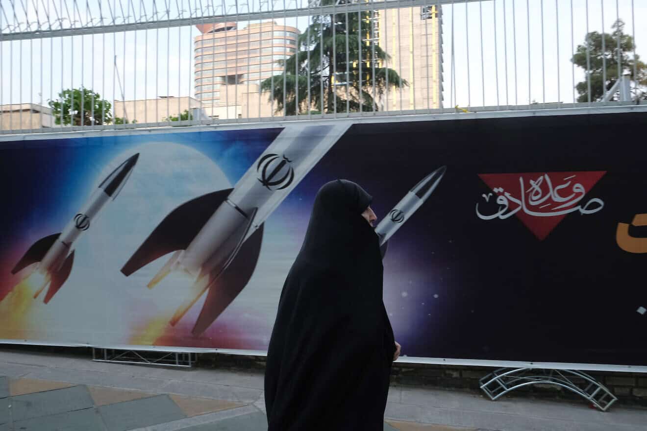 An Iran passes by banners outside a government building in Tehran depicting the April 13 missile strike on Israel, April 17, 2024. Photo by Kaveh Kazemi/Getty Images.