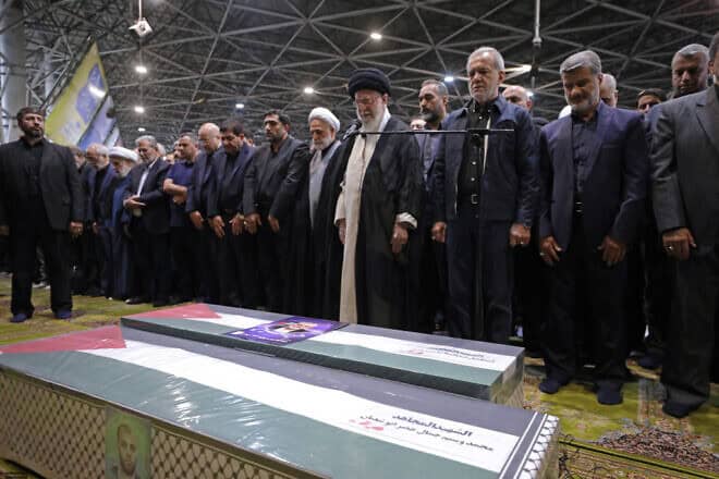 In this handout image from the Office of the Iranian Supreme Leader, Supreme Leader Ayatollah Ali Khamenei, center, leads a prayer over the coffins of Hamas leader Ismail Haniyeh and his bodyguard at Tehran University on Aug. 1, 2024. Credit Office of the Iranian Supreme Leader via Getty Images.
