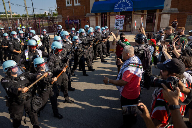 Chicago police officers protect a barrier from anti-Israel protesters near the Democratic National Convention at the United Center on Aug. 19, 2024. Photo by John Moore/Getty Images.