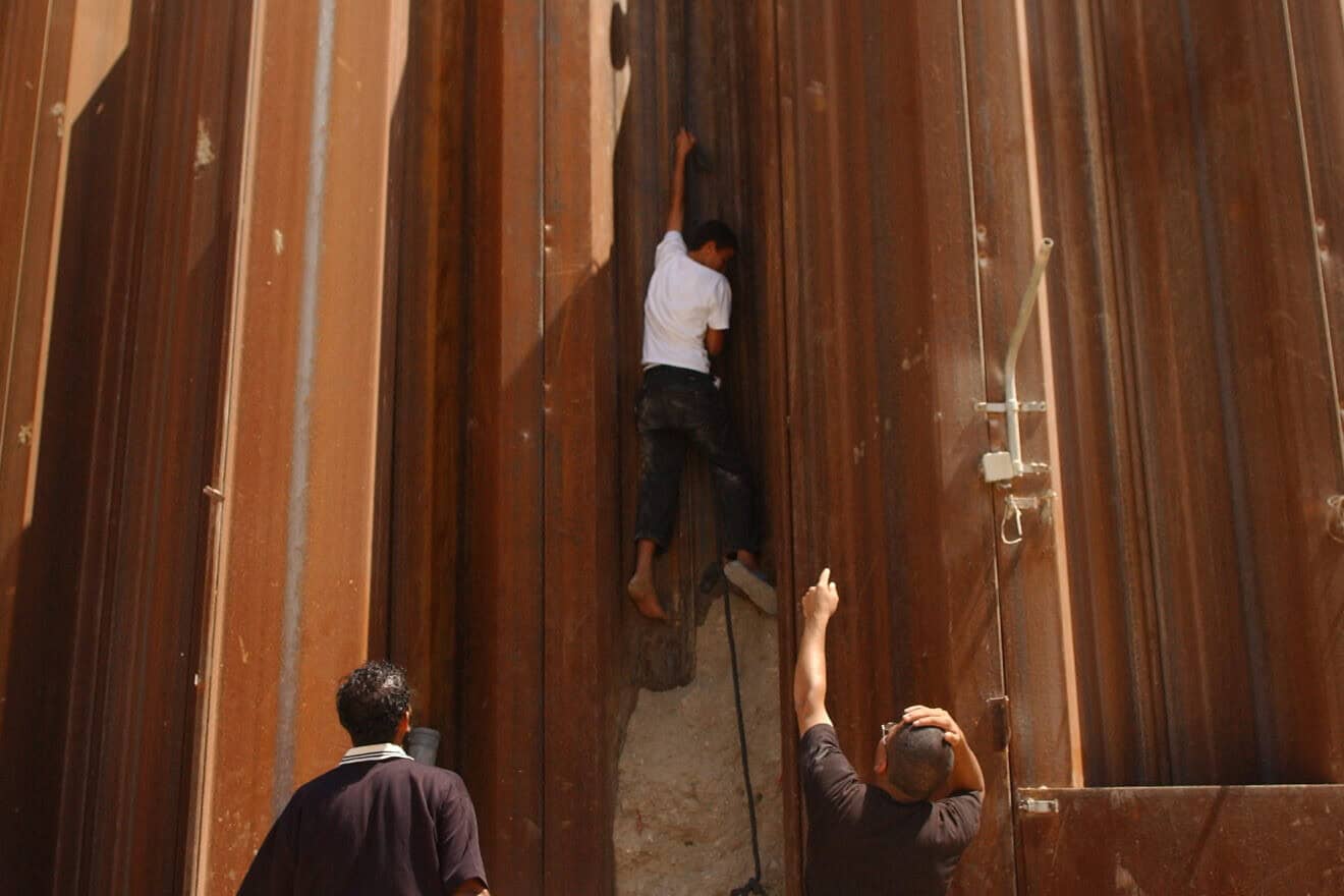 A Palestinian boy from Rafah climbs down into the Philadelphi Corridor from the wall that separated Gaza from Sinai before Israel’s disengagement from the Strip, Sept. 13, 2005. Photo by Yossi Zamir/Flash90.