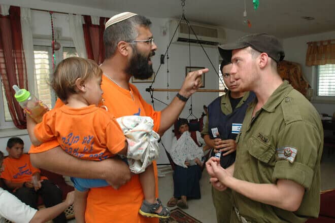 IDF soldiers remove civilians from their home in Netzarim as part of the disengagement from the Gaza Strip, Aug. 22, 2005. Credit: Flash90.